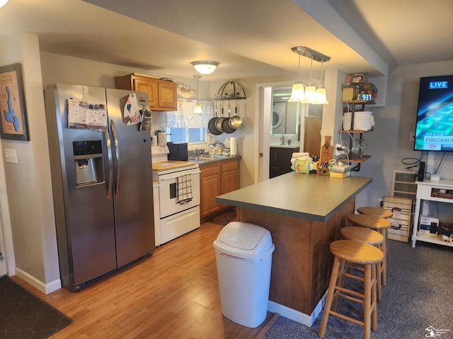 295 Grove St, Manitou Beach, MI 49235 - kitchen featuring stainless steel fridge with ice dispenser, white electric stove, a breakfast bar, a peninsula, and stacked washer / dryer