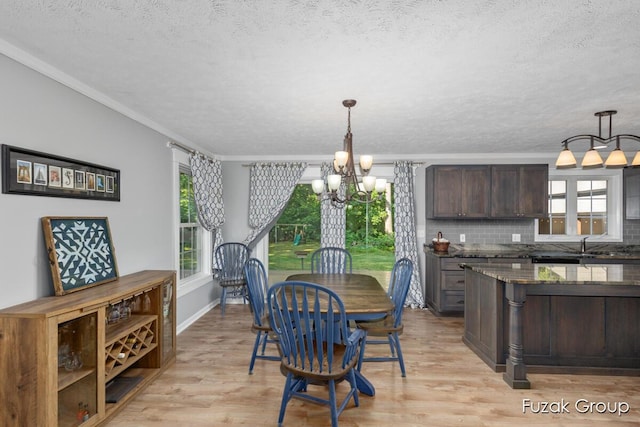3268 Michele Ln, Hamilton, MI 49419 - dining space featuring a chandelier, a textured ceiling, ornamental molding, and light wood finished floors