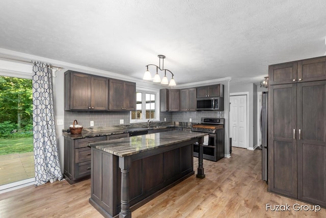 3268 Michele Ln, Hamilton, MI 49419 - kitchen with appliances with stainless steel finishes, tasteful backsplash, dark brown cabinetry, light wood-style floors, and a textured ceiling