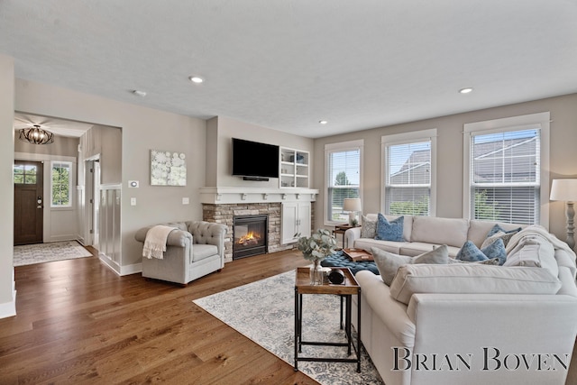9633 Waterstone Dr, Byron Center, MI 49315 - living room with wood finished floors, recessed lighting, a fireplace, and a chandelier