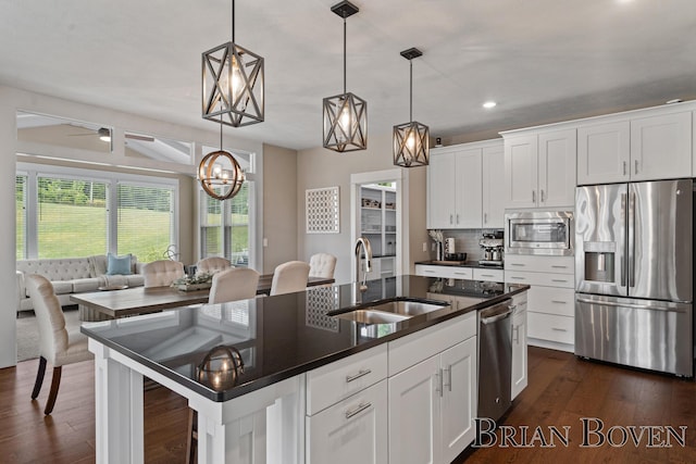 9633 Waterstone Dr, Byron Center, MI 49315 - kitchen featuring stainless steel appliances, recessed lighting, dark wood-style flooring, tasteful backsplash, and an island with sink
