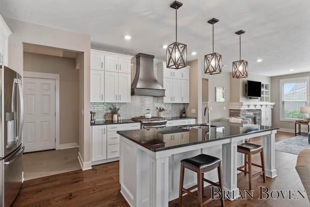 9633 Waterstone Dr, Byron Center, MI 49315 - kitchen with wall chimney range hood, stainless steel appliances, dark countertops, open floor plan, and tasteful backsplash