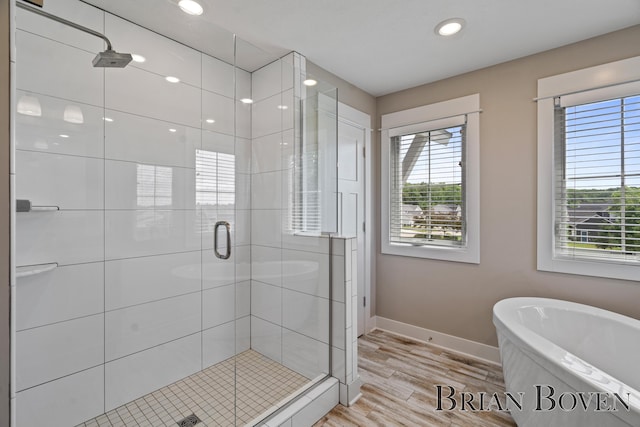 9633 Waterstone Dr, Byron Center, MI 49315 - bathroom with plenty of natural light, a stall shower, a freestanding tub, and recessed lighting