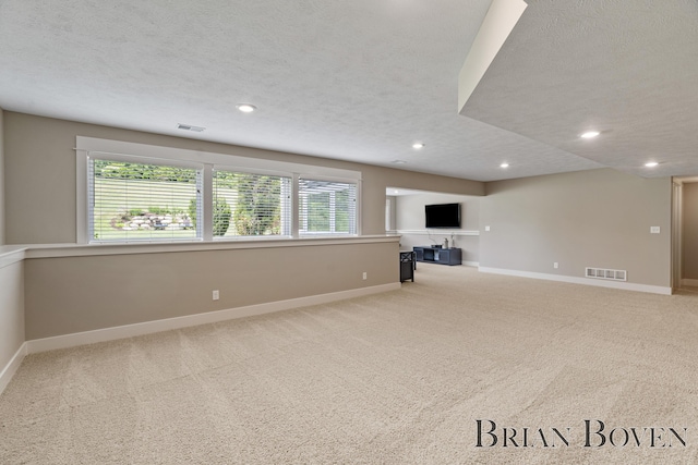9633 Waterstone Dr, Byron Center, MI 49315 - unfurnished living room featuring a textured ceiling, carpet flooring, and recessed lighting