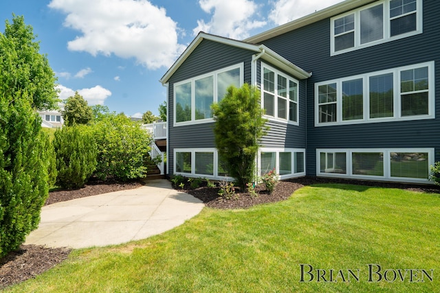 9633 Waterstone Dr, Byron Center, MI 49315 - rear view of house with a yard, a patio area, stairs, and a sunroom