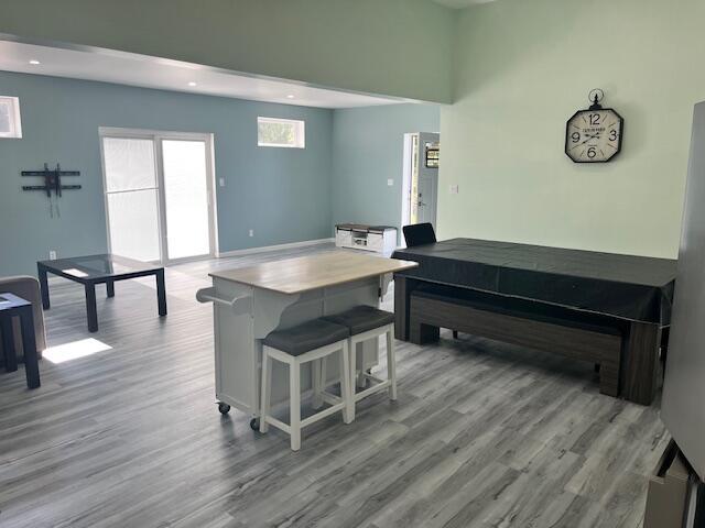 4969 N Highbridge Rd, Brethren, MI 49619 - kitchen featuring wood finished floors, recessed lighting, and a breakfast bar area