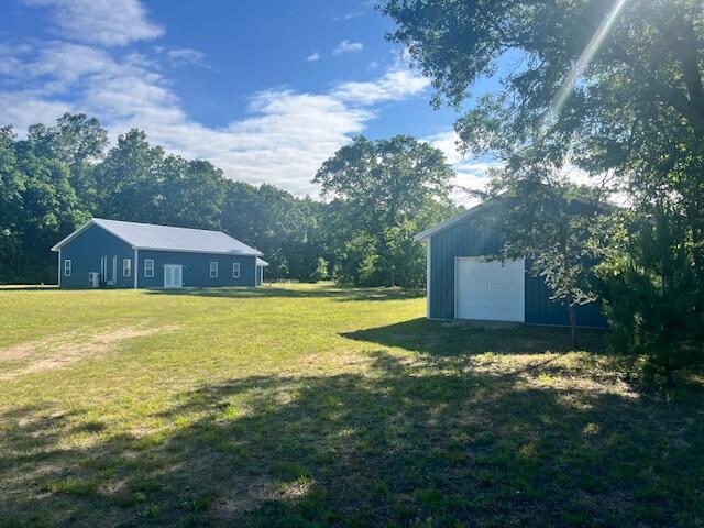 4969 N Highbridge Rd, Brethren, MI 49619 - view of grassy yard with an outdoor structure and a garage