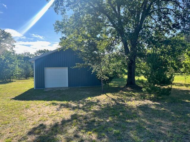 4969 N Highbridge Rd, Brethren, MI 49619 - view of grassy yard featuring an outbuilding and a garage