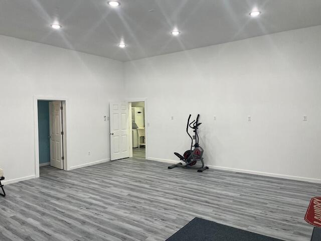 4969 N Highbridge Rd, Brethren, MI 49619 - empty room with wood finished floors, recessed lighting, and a towering ceiling