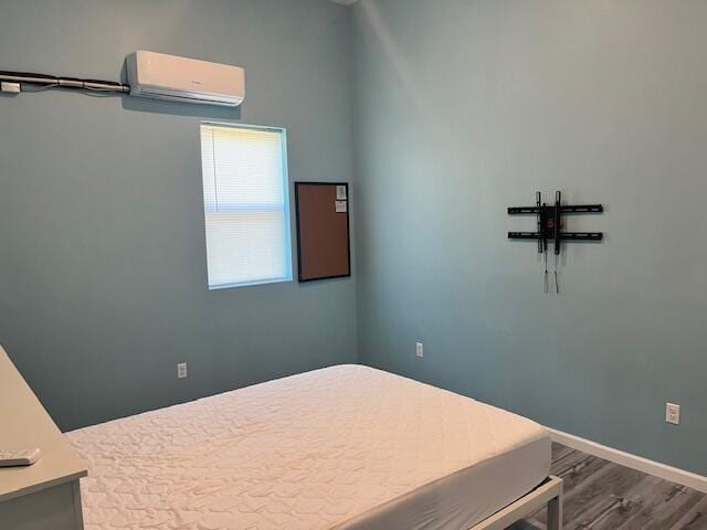 4969 N Highbridge Rd, Brethren, MI 49619 - unfurnished bedroom with a wall mounted AC and wood finished floors