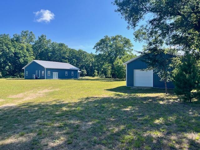 4969 N Highbridge Rd, Brethren, MI 49619 - view of grassy yard with an outdoor structure and a detached garage
