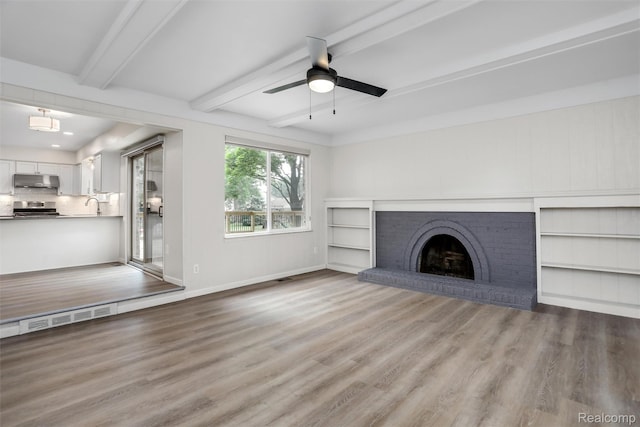 684 Abbey Ct, Rochester Hills, MI 48307 - unfurnished living room featuring a ceiling fan, beamed ceiling, wood finished floors, and a fireplace