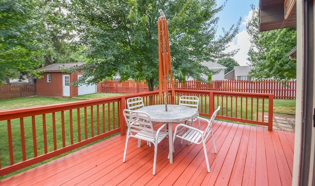 215 W State St, Coldwater, MI 49036 - wooden deck featuring outdoor dining space, a fenced backyard, and an outdoor structure