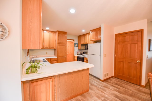 215 W State St, Coldwater, MI 49036 - kitchen with white appliances, light countertops, light wood finished floors, a peninsula, and recessed lighting