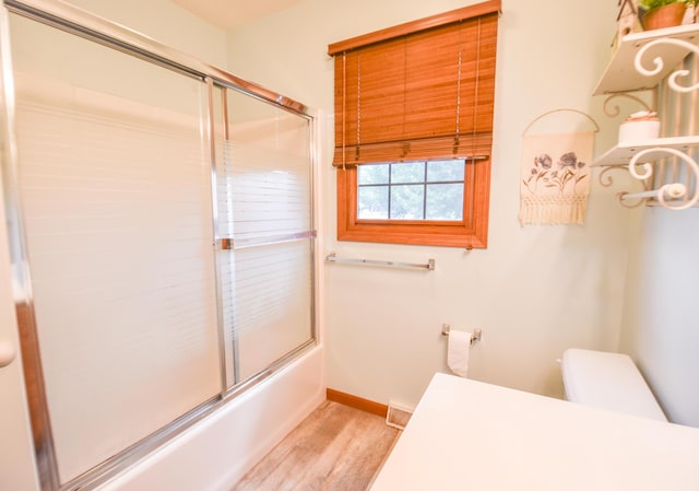 215 W State St, Coldwater, MI 49036 - bathroom featuring wood finished floors and bath / shower combo with glass door
