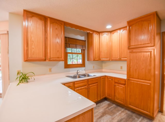 215 W State St, Coldwater, MI 49036 - kitchen featuring light countertops, recessed lighting, wood finished floors, brown cabinetry, and a textured ceiling