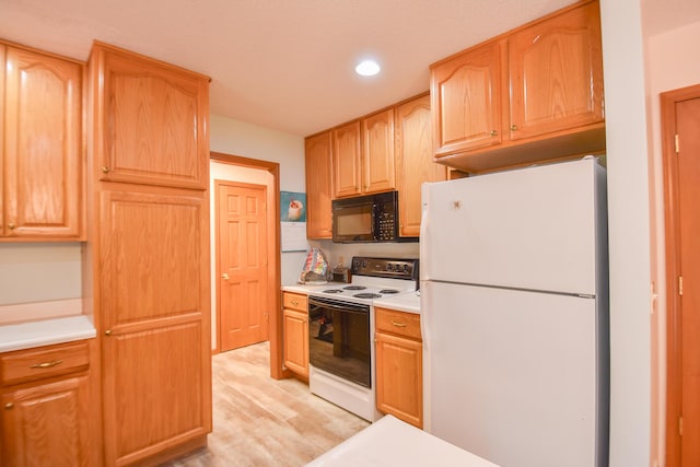 215 W State St, Coldwater, MI 49036 - kitchen with white appliances, light wood finished floors, light countertops, and recessed lighting