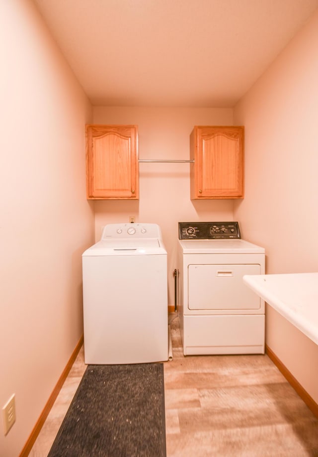 215 W State St, Coldwater, MI 49036 - washroom featuring washing machine and clothes dryer, cabinet space, and light wood-type flooring