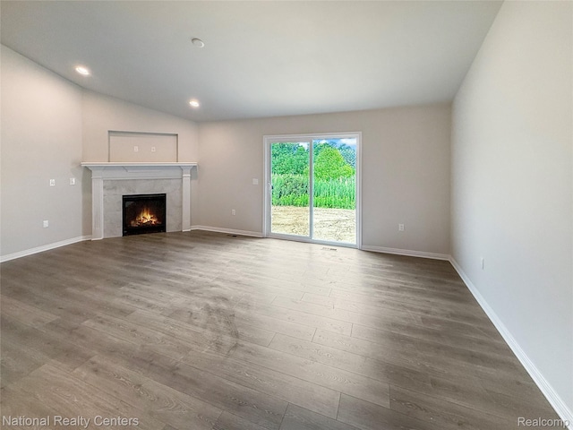 253 Devonshire Dr Unit 2, Lapeer, MI 48446 - unfurnished living room with wood finished floors, a premium fireplace, recessed lighting, and lofted ceiling