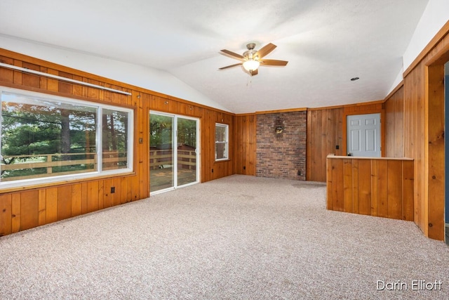 7985 Island View Dr, Newaygo, MI 49337 - unfurnished living room featuring ceiling fan, vaulted ceiling, wood walls, and carpet floors
