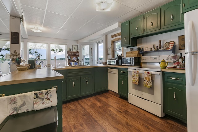 68534 Hill St, Sturgis, MI 49091 - kitchen featuring green cabinetry, white appliances, a paneled ceiling, dark wood-style floors, and a peninsula