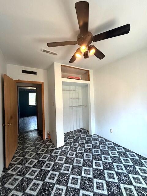 4807 118th Ave, Fennville, MI 49408 - unfurnished bedroom featuring a closet, dark flooring, and a ceiling fan