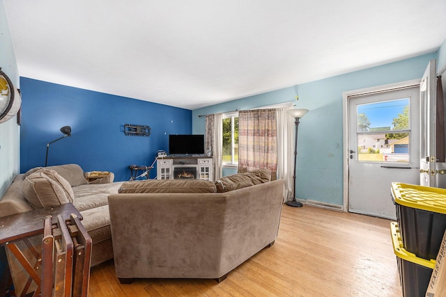 1556 Mullins Ave NW, Grand Rapids, MI 49534 - living room featuring light wood-style floors and a lit fireplace