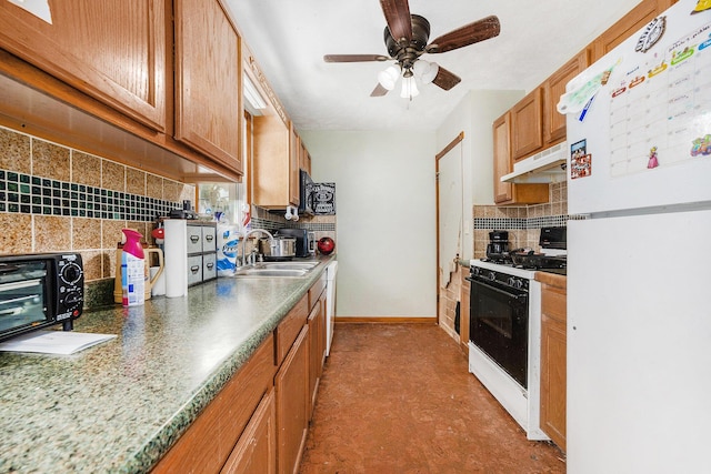 1556 Mullins Ave NW, Grand Rapids, MI 49534 - kitchen with freestanding refrigerator, gas stove, under cabinet range hood, tasteful backsplash, and a ceiling fan