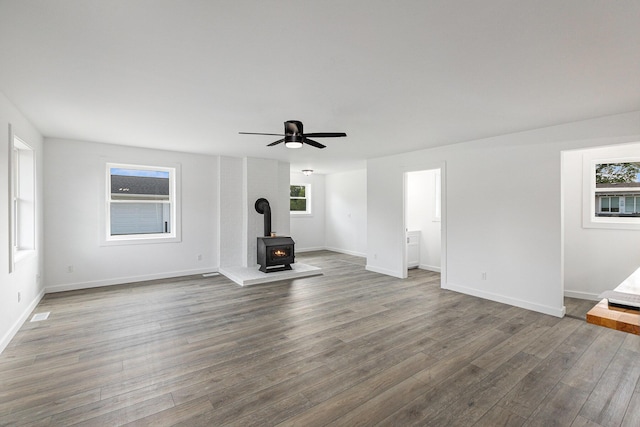 287 Somerset Dr, Brooklyn, MI 49230 - unfurnished living room featuring a wood stove, wood finished floors, and ceiling fan