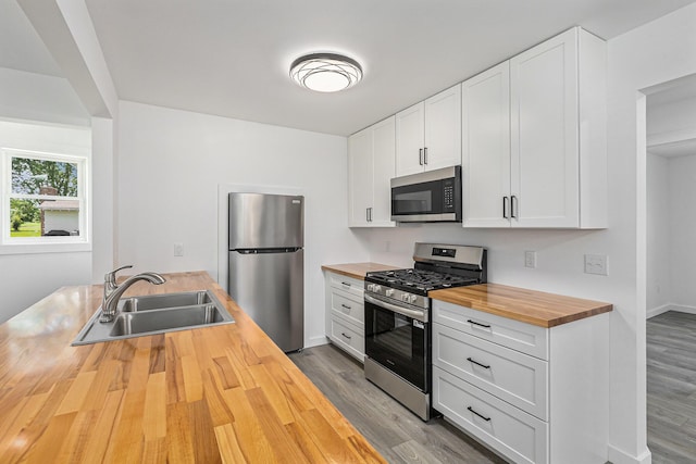 287 Somerset Dr, Brooklyn, MI 49230 - kitchen featuring butcher block countertops, appliances with stainless steel finishes, wood finished floors, and white cabinetry