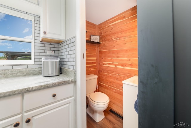 14079 Elms Rd, Montrose, MI 48457 - bathroom featuring wooden walls, vanity, backsplash, and wood finished floors