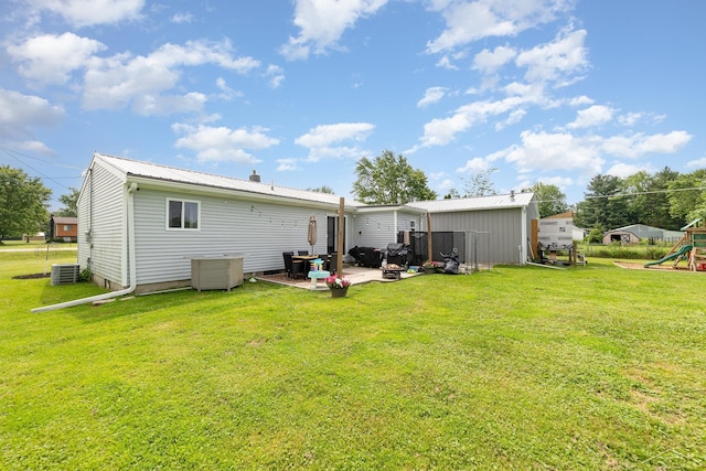 14079 Elms Rd, Montrose, MI 48457 - back of property featuring a playground, a lawn, a metal roof, and a patio area