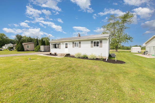 14079 Elms Rd, Montrose, MI 48457 - view of front of home featuring a shed, a front lawn, a metal roof, and a chimney