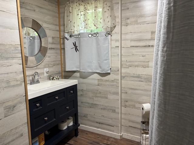 4384 Loud Dam Rd, Glennie, MI 48737 - bathroom with wooden walls, vanity, and wood finished floors