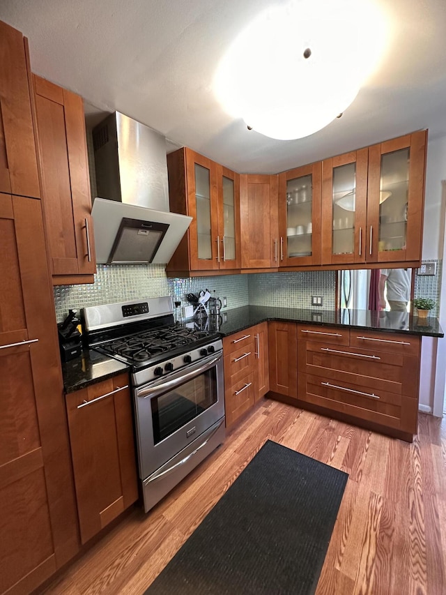 26314 E St, Saint Clair Shores, MI 48081 - kitchen featuring stainless steel range with gas cooktop, wall chimney range hood, light wood finished floors, brown cabinetry, and decorative backsplash