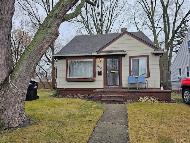 19356 Huntington Rd, Detroit, MI 48219 - bungalow-style home with a chimney, a front yard, roof with shingles, and covered porch