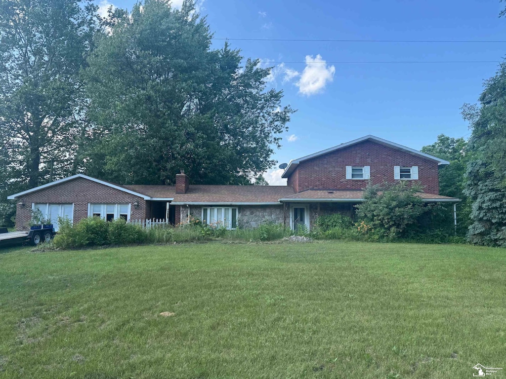 11620 Stewart Rd, Dundee, MI 48131 - view of front facade featuring a front yard, a chimney, a garage, and brick siding