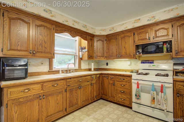 3092 Dillon Rd, Flushing, MI 48433 - kitchen featuring white range with gas cooktop, black microwave, brown cabinets, light floors, and light countertops