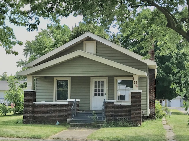 104 N Kalamazoo St, White Pigeon, MI 49099 - bungalow-style house with brick siding, a porch, and a chimney