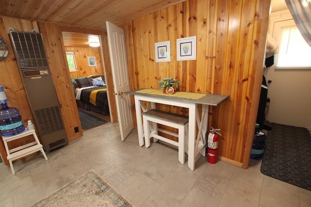 8905 E Acorn St, Holton, MI 49425 - dining space featuring wood walls, a heating unit, plenty of natural light, and wooden ceiling