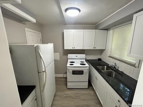 15452 Southfield Rd, Detroit, MI 48223 - kitchen featuring white appliances, white cabinetry, and dark countertops