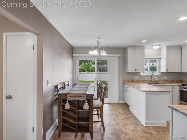 29553 Pinto Dr, Warren, MI 48093 - kitchen featuring plenty of natural light, stainless steel gas stove, light stone counters, a chandelier, and recessed lighting