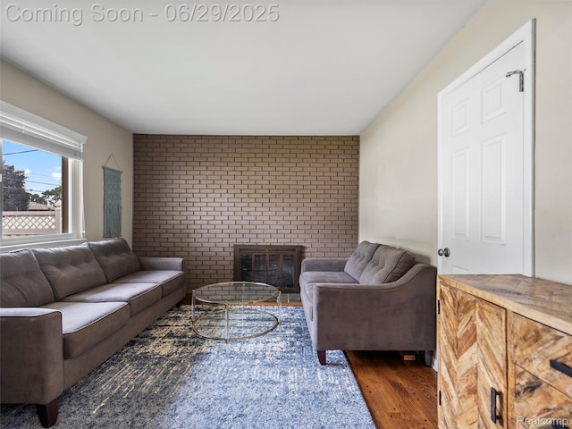 29553 Pinto Dr, Warren, MI 48093 - living room featuring brick wall, a brick fireplace, wood finished floors, and an accent wall