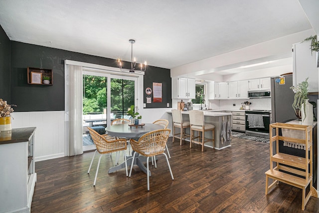 3042 Kevin St, Saint Joseph, MI 49085 - dining room featuring dark wood finished floors, plenty of natural light, a wainscoted wall, and a chandelier