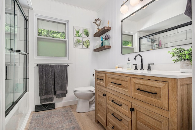 3042 Kevin St, Saint Joseph, MI 49085 - full bathroom with ornamental molding, vanity, wood finished floors, and bath / shower combo with glass door