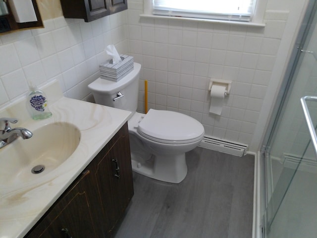 1602 Blakely Ave, Jackson, MI 49202 - full bath featuring a baseboard heating unit, tile walls, a shower with shower door, vanity, and healthy amount of natural light
