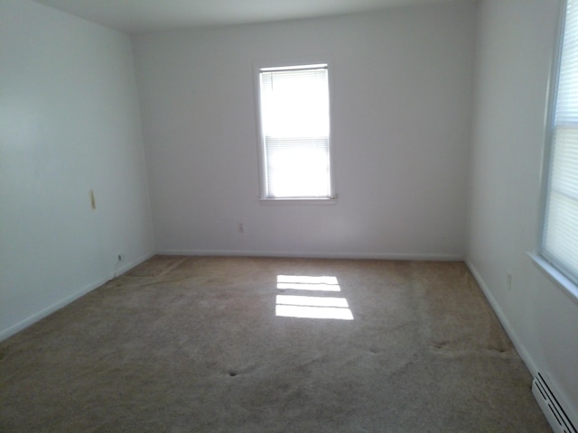 1602 Blakely Ave, Jackson, MI 49202 - carpeted spare room featuring a baseboard radiator and healthy amount of natural light