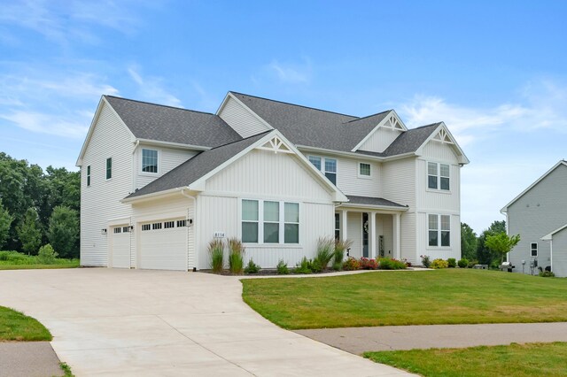 8114 Turning Stone, Kalamazoo, MI 49009 - view of front facade featuring an attached garage, concrete driveway, a front lawn, a shingled roof, and board and batten siding