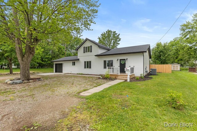 412 S Woodworth St, Corunna, MI 48817 - rear view of property with a storage shed, concrete driveway, a garage, a lawn, and roof with shingles