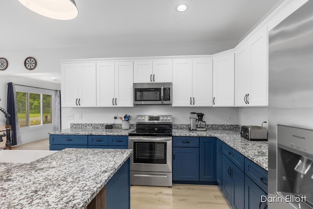 412 S Woodworth St, Corunna, MI 48817 - kitchen featuring appliances with stainless steel finishes, blue cabinets, white cabinets, recessed lighting, and light wood-style floors